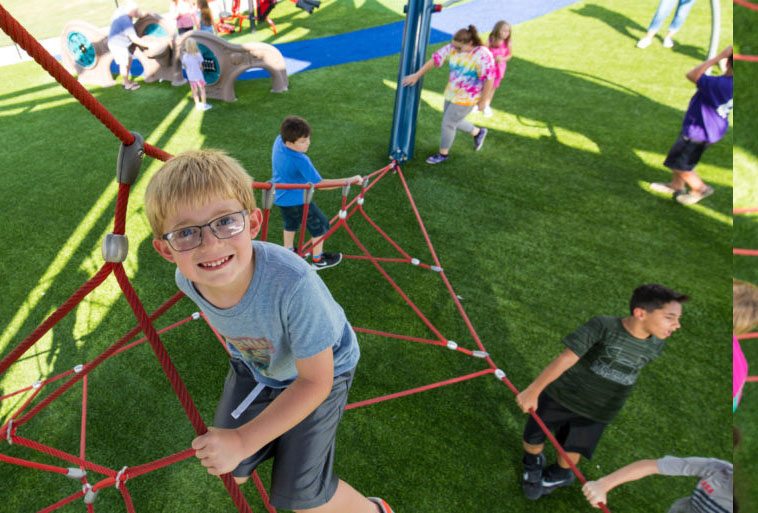 Mt. Kids playing at Mt. Ton of Fun featuring Playground Grass by ForeverLawn