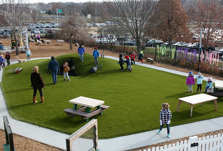 Kids playing on Playground Grass Ultra by ForeverLawn at Security Benefit Academy child care center in Topeka, Kansas